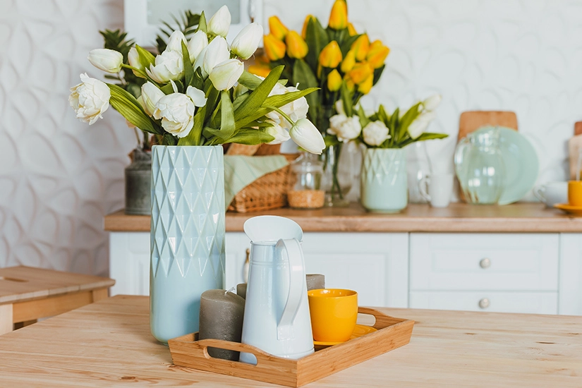 Wiosenna dekoracja stołu, tulipany w niebieskim wazonie.